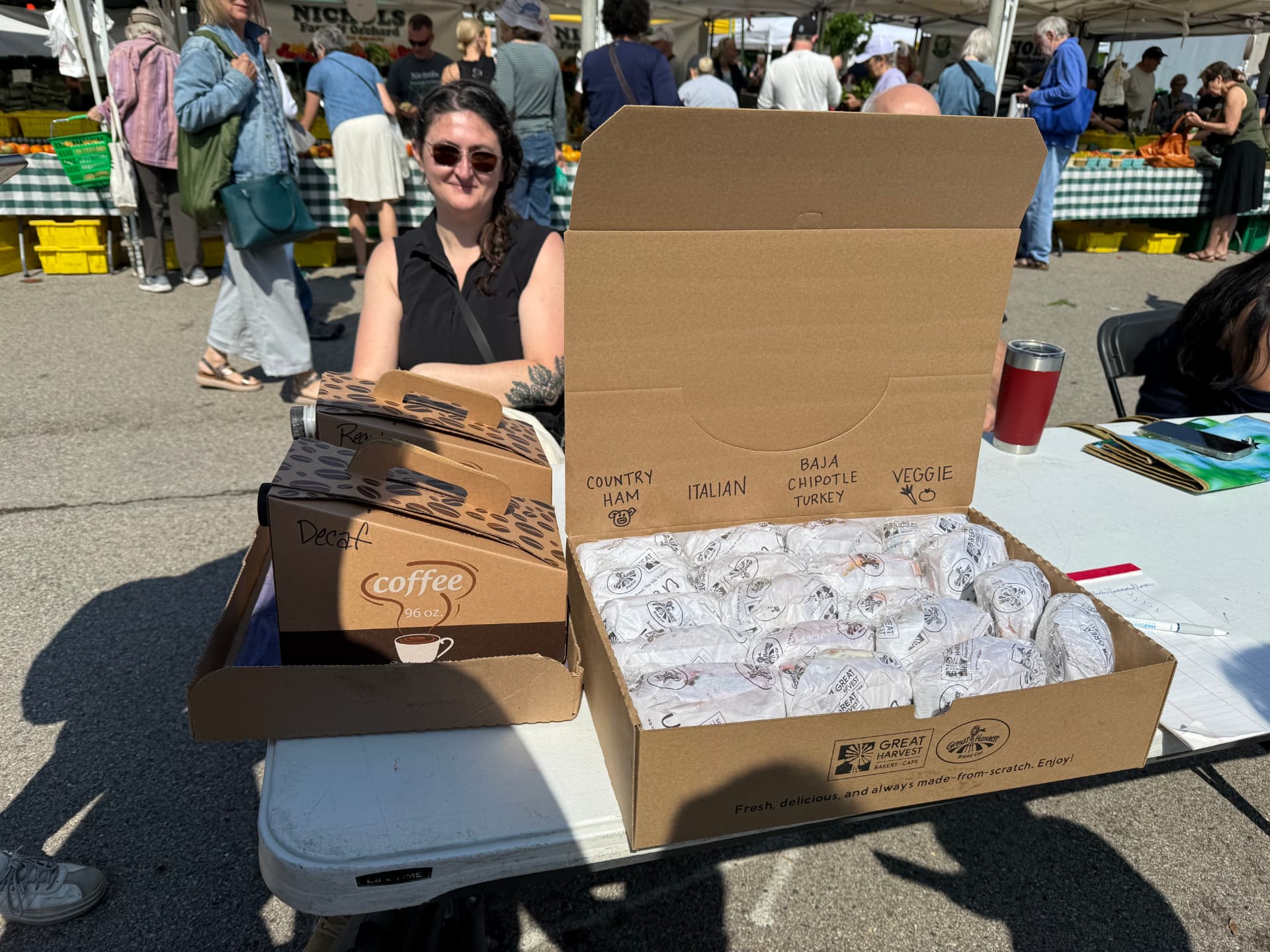 G-ISA table at the Evanston Farmer's Market with bagels, coffee, and attendees